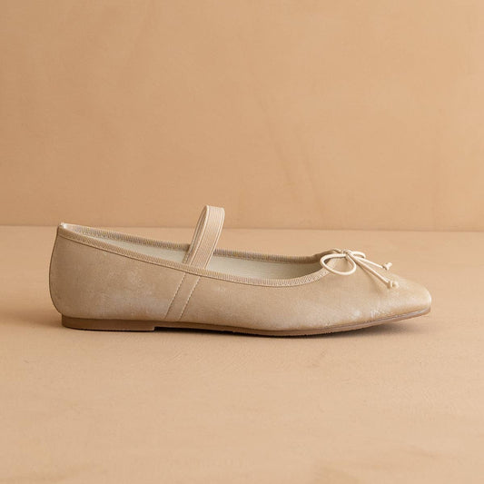 Beige flat shoe with a bow on a beige background