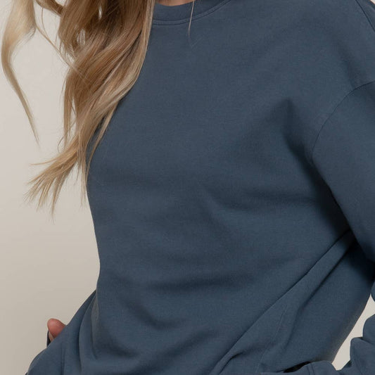 Person wearing a blue sweatshirt with a neutral background