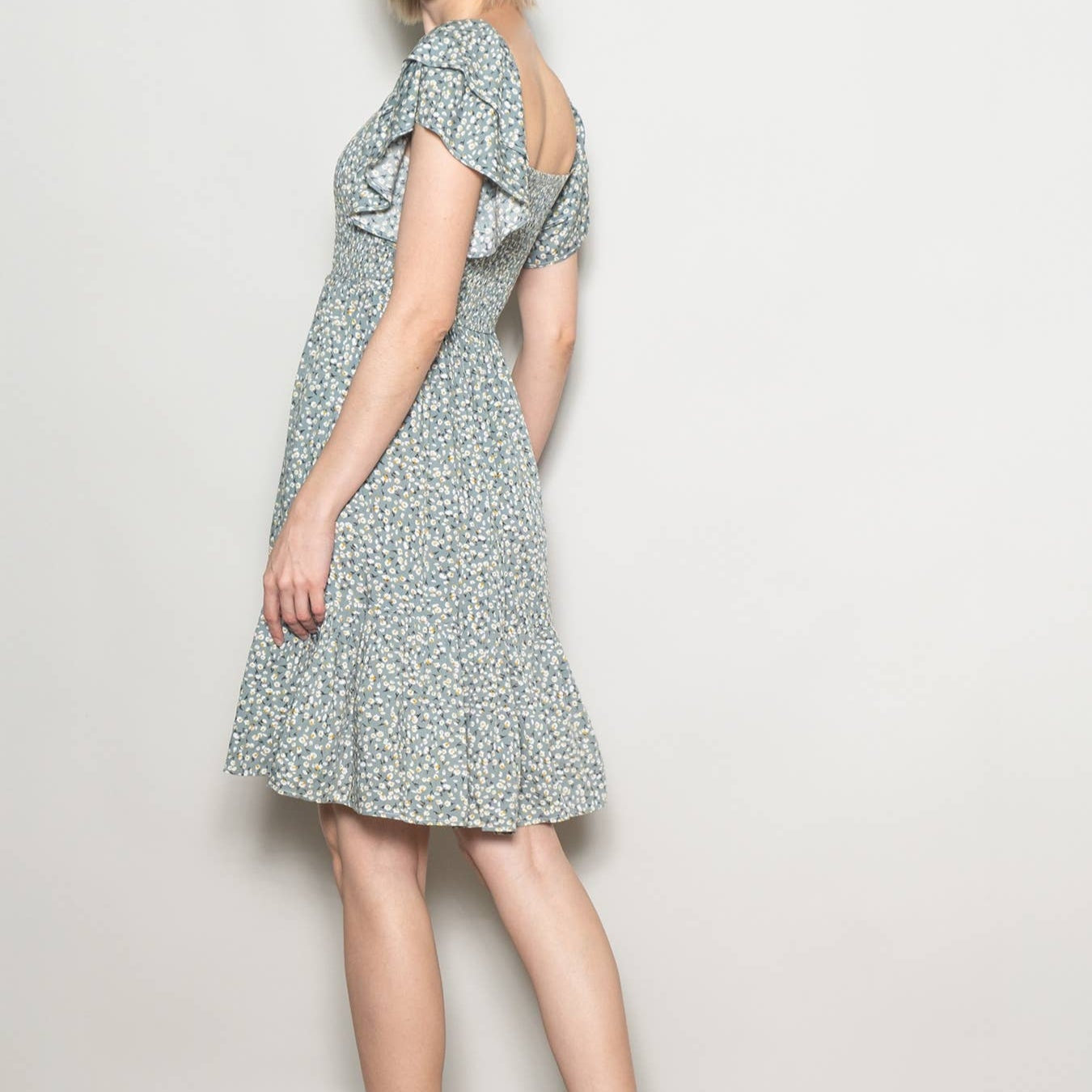 Woman wearing a floral dress against a plain background