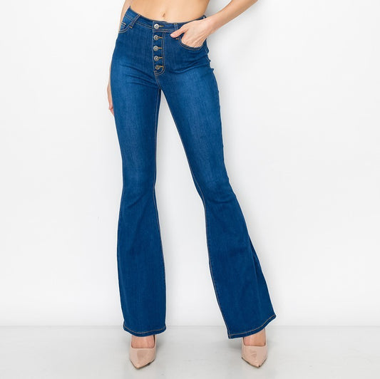 A pair of flare jeans with button fly detail, in indigo color, displayed on a model without showing the upper part of the body.