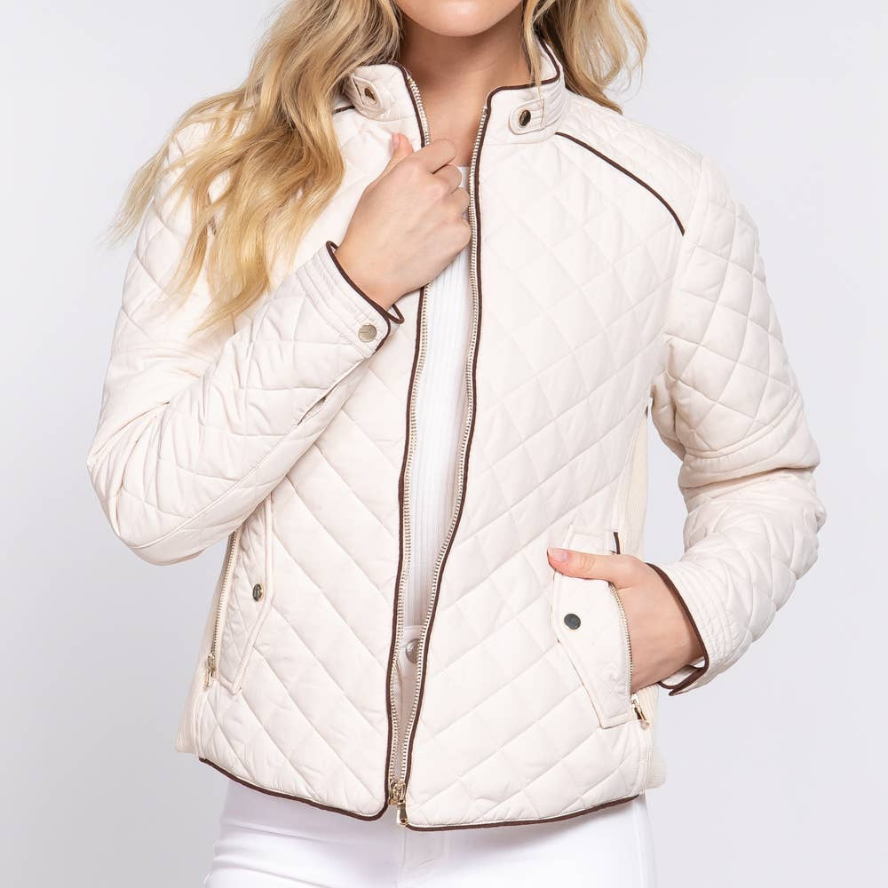 Woman wearing a white quilted jacket on a light gray background