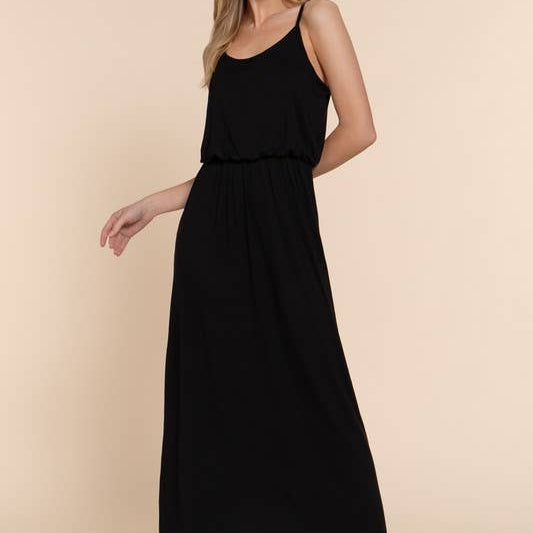 Woman wearing a black sleeveless dress against a beige background