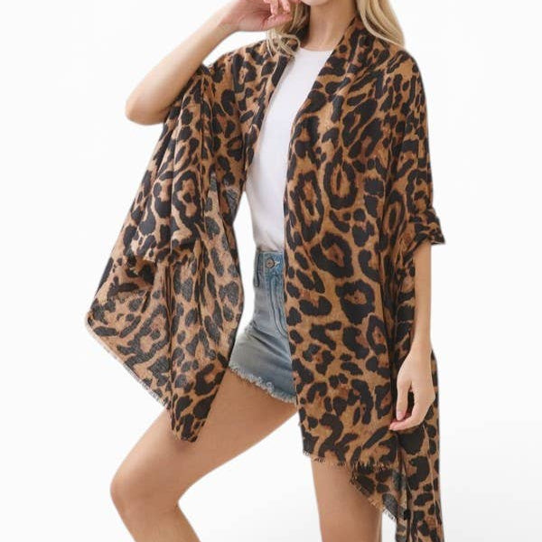 A woman modeling a leopard print open-front kimono cardigan over a white t-shirt and denim shorts, set against a plain white studio background.