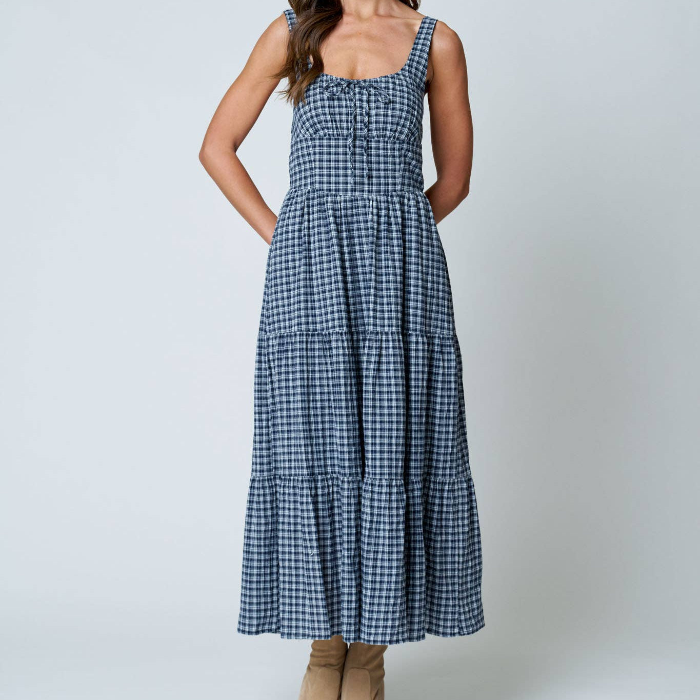 Woman wearing a blue checkered dress on a white background