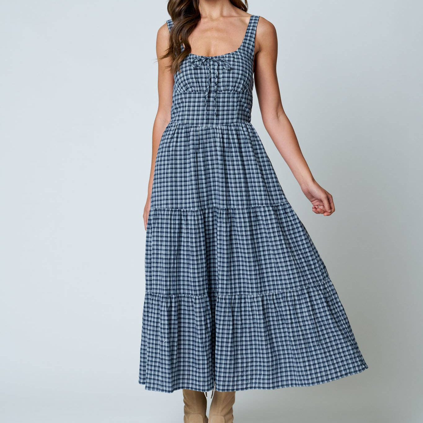Woman wearing a blue checkered dress on a white background