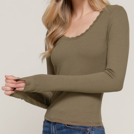 Woman wearing a green ribbed long-sleeve top against a plain background