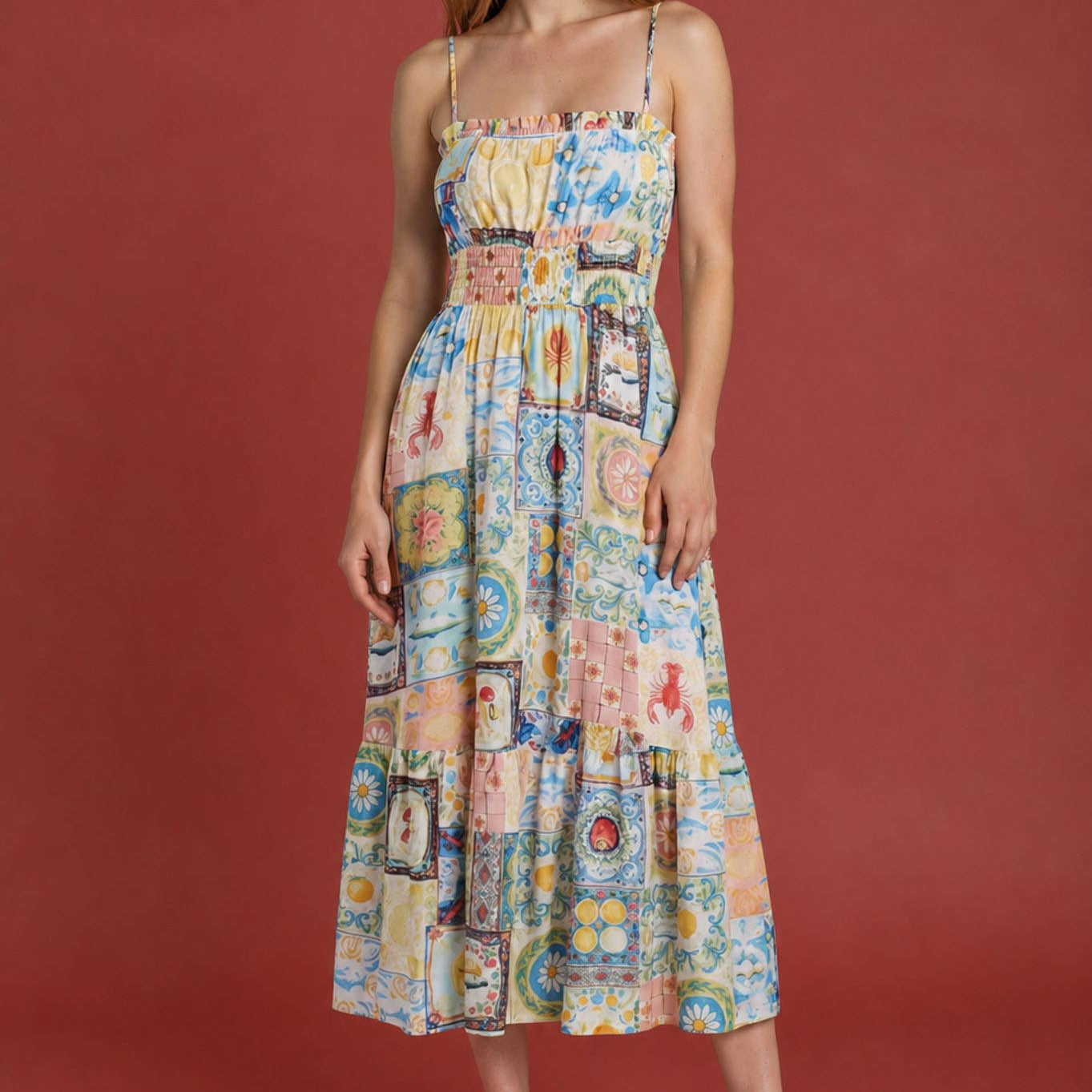 Woman wearing a colorful patterned dress against a red background