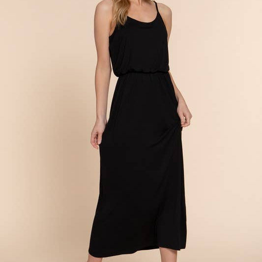 Woman wearing a black sleeveless dress against a beige background