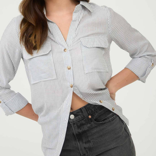 Woman wearing a striped shirt with rolled-up sleeves against a white background