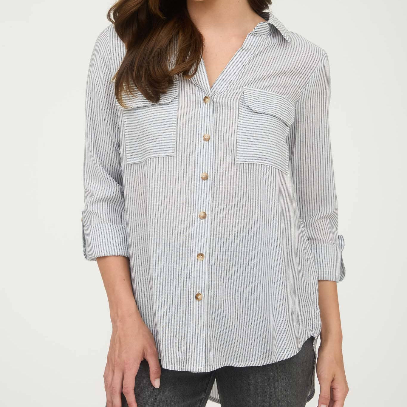Woman wearing a striped shirt with a plain background