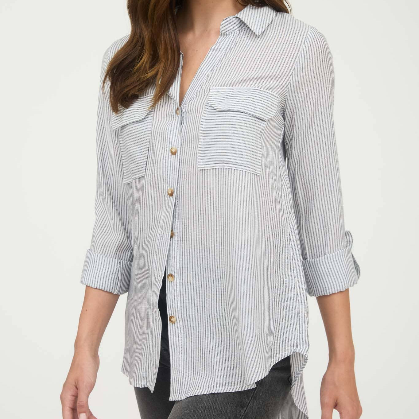 Woman wearing a striped shirt with rolled-up sleeves on a white background