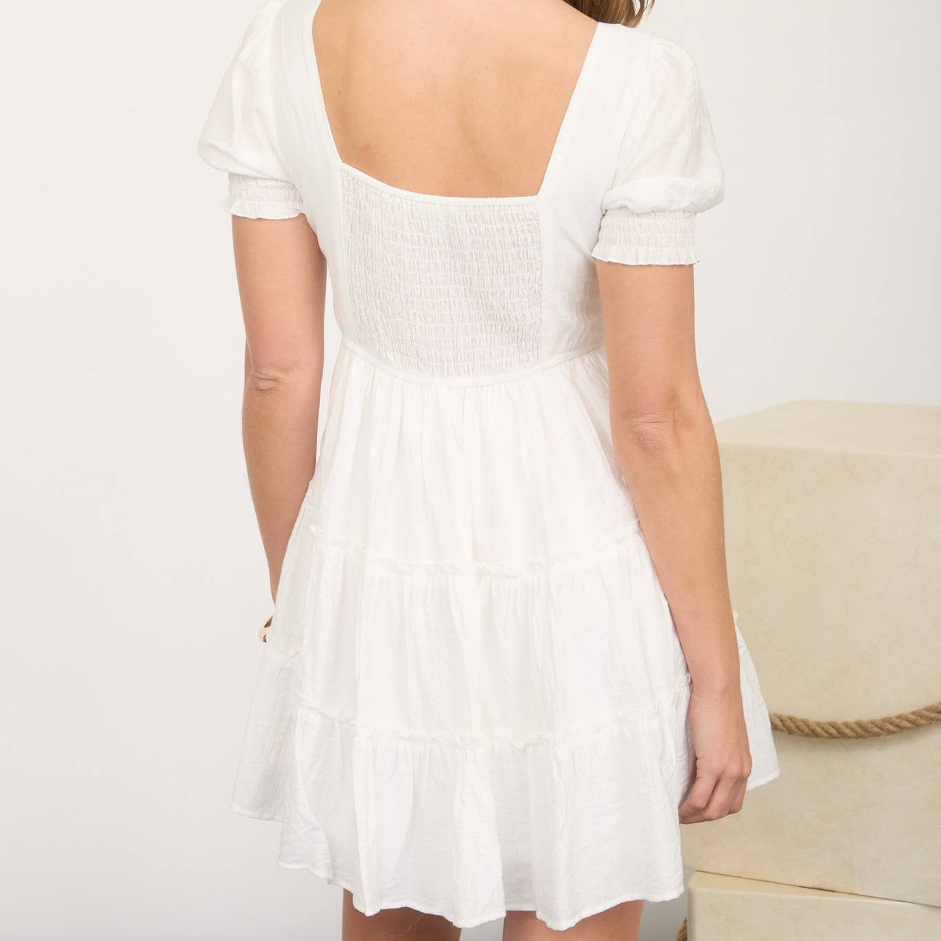 Woman wearing a white dress with a plain background