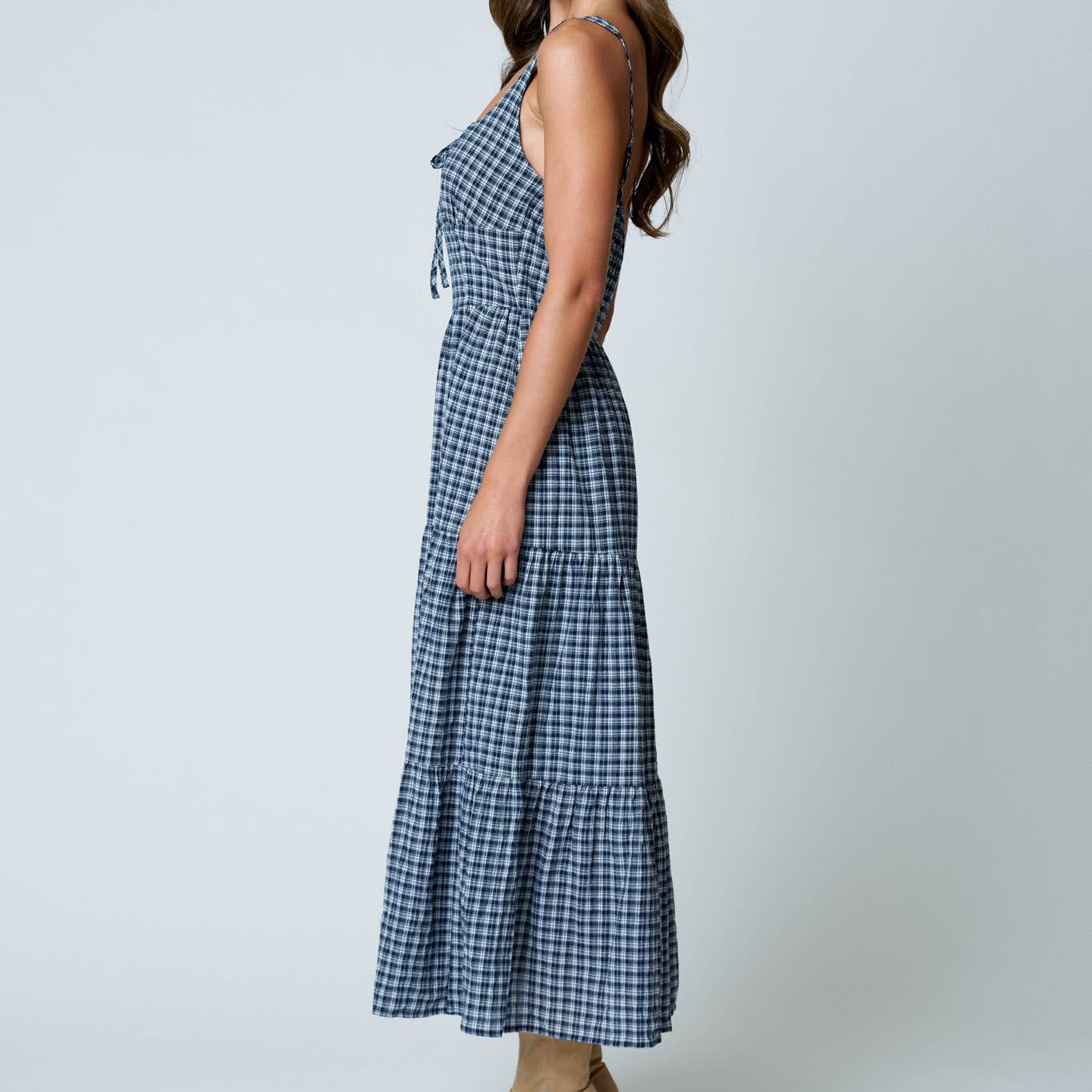 Woman wearing a blue checkered dress on a white background