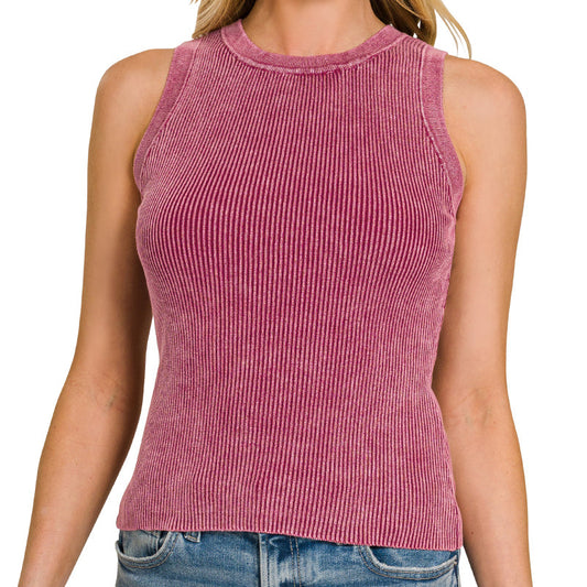 Woman wearing a pink ribbed tank top and blue jeans on a white background