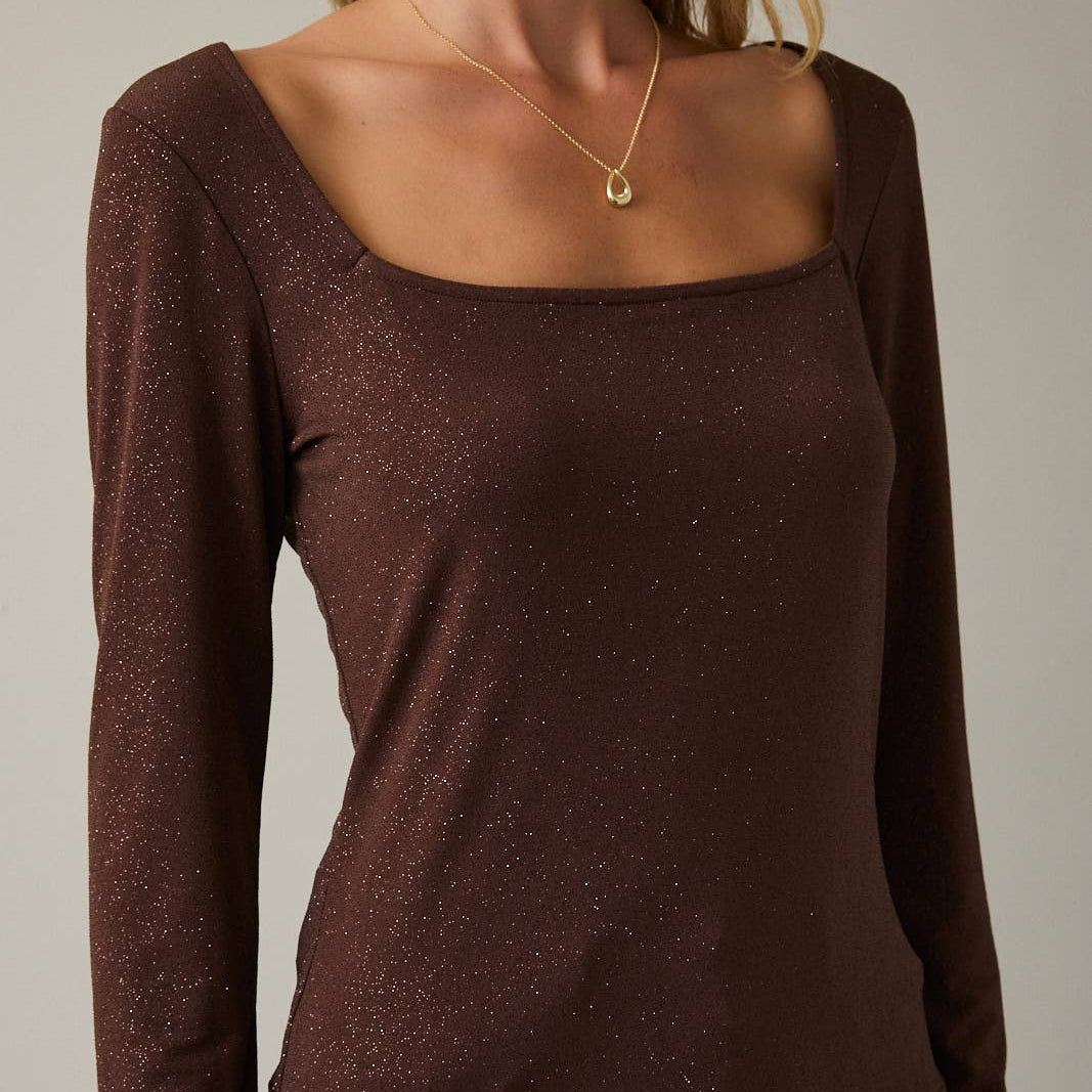 Brown long-sleeve top worn by a person on a neutral background