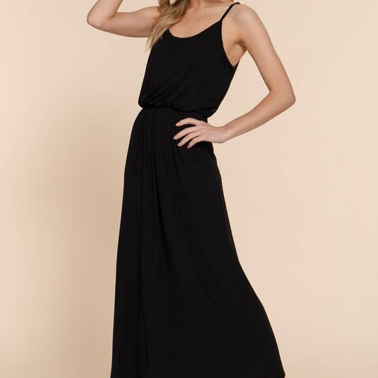 Woman wearing a black sleeveless dress against a beige background