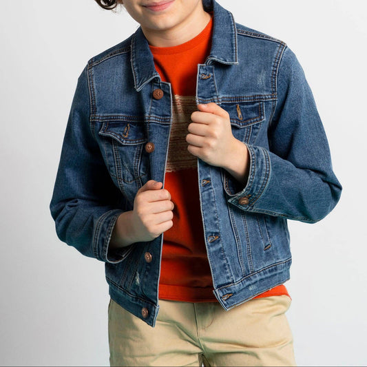 Child wearing a denim jacket over an orange shirt on a plain background