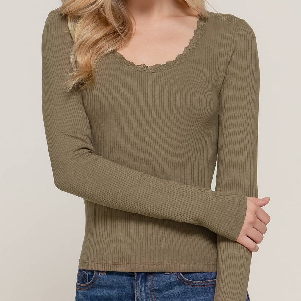 Woman wearing a green long-sleeve top against a plain background