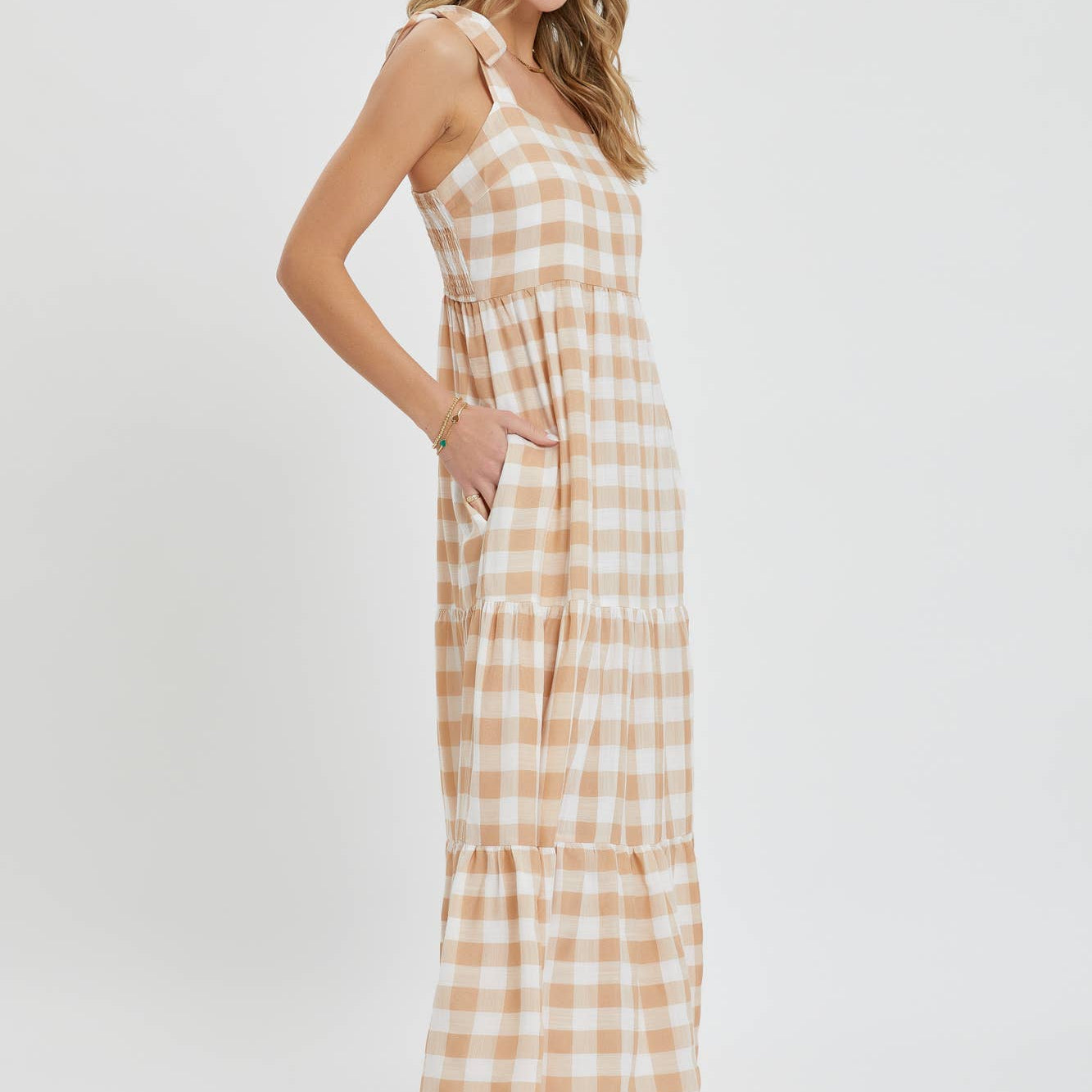 Woman wearing a beige and white checkered dress on a white background