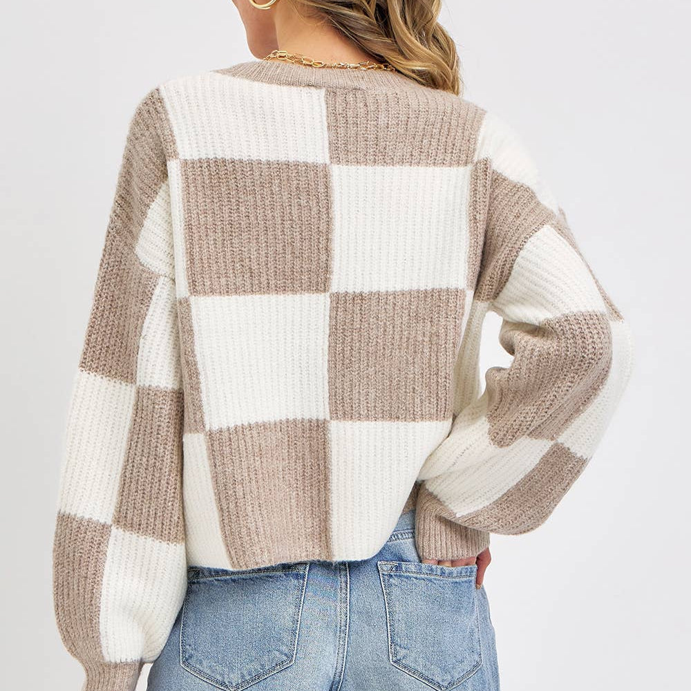Person wearing a checkered sweater and denim shorts on a white background
