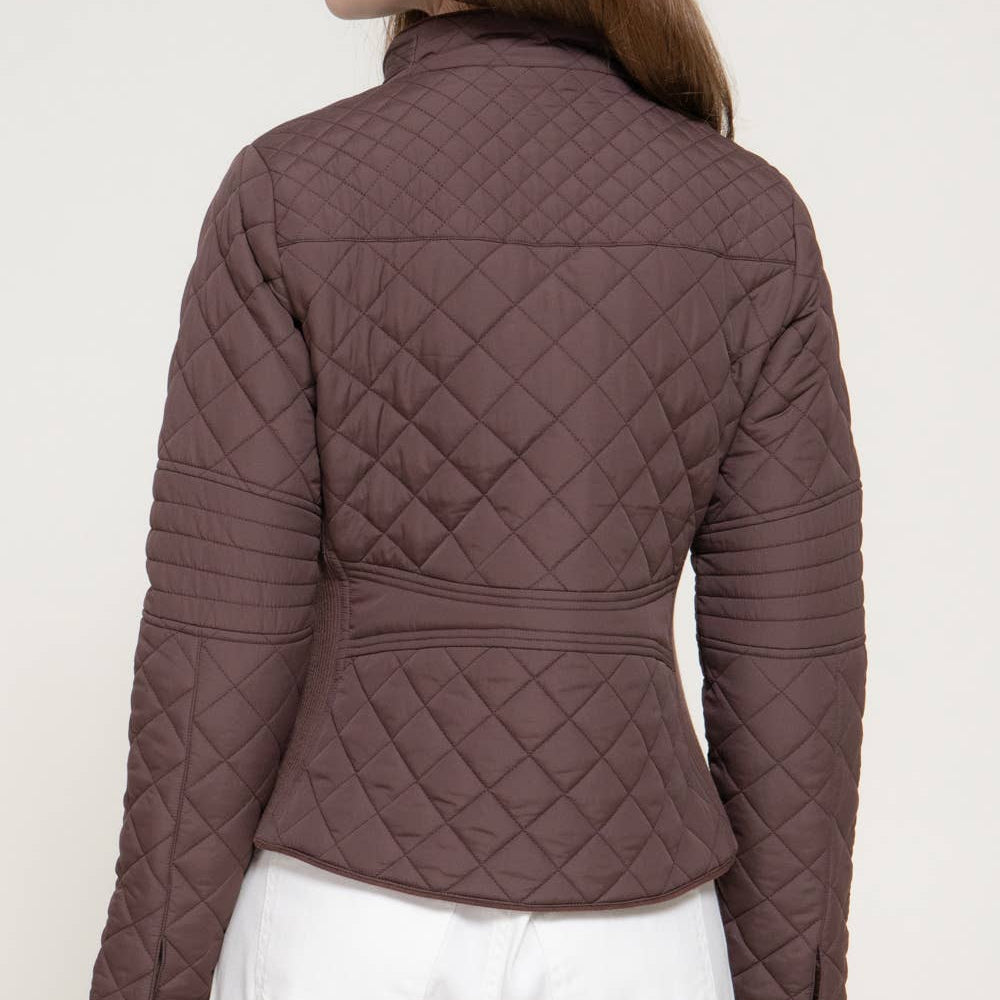 A woman shown from the back wearing a brown diamond-quilted cropped jacket with white pants, against a plain light background. A small black label in the top right corner reads 'PLUS SIZE'.