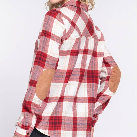 Woman wearing a red and white plaid shirt on a plain background