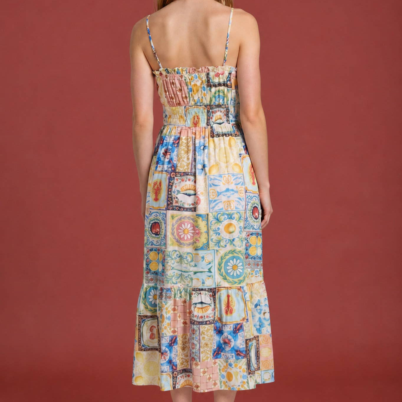 Woman wearing a colorful patchwork dress against a red background