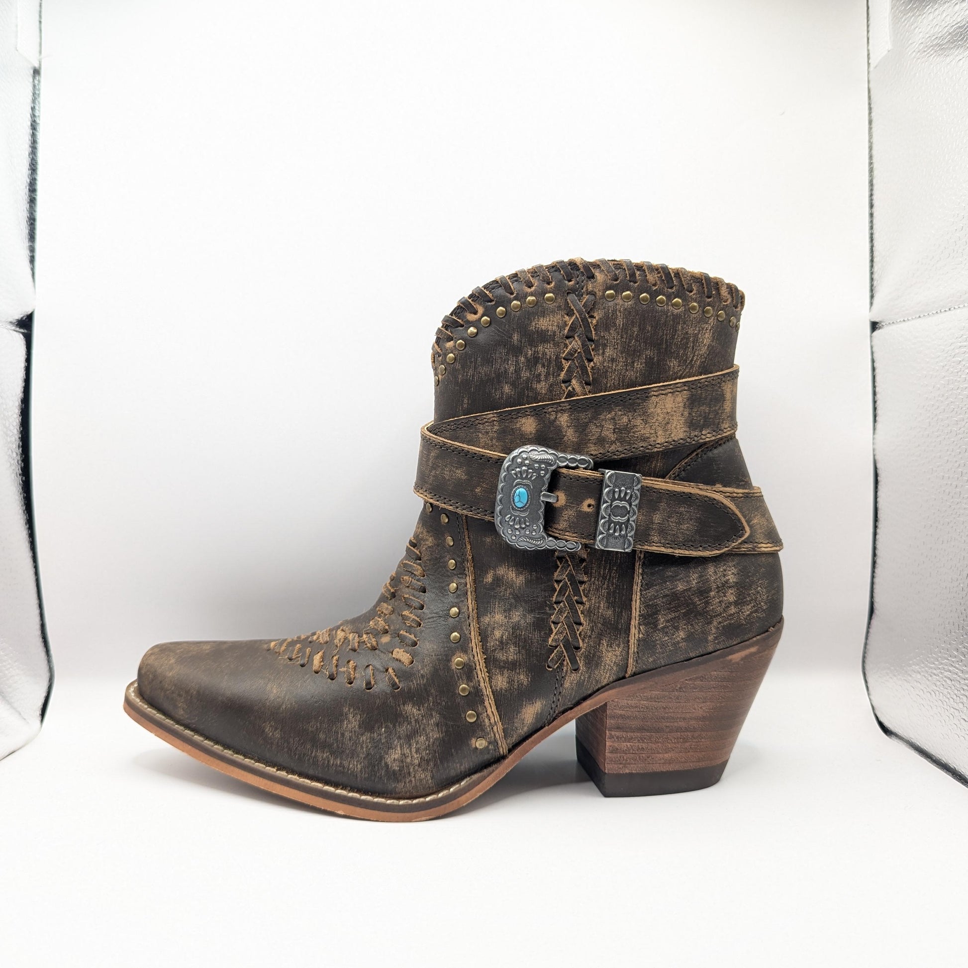 Brown distressed boot with a buckle on a white background